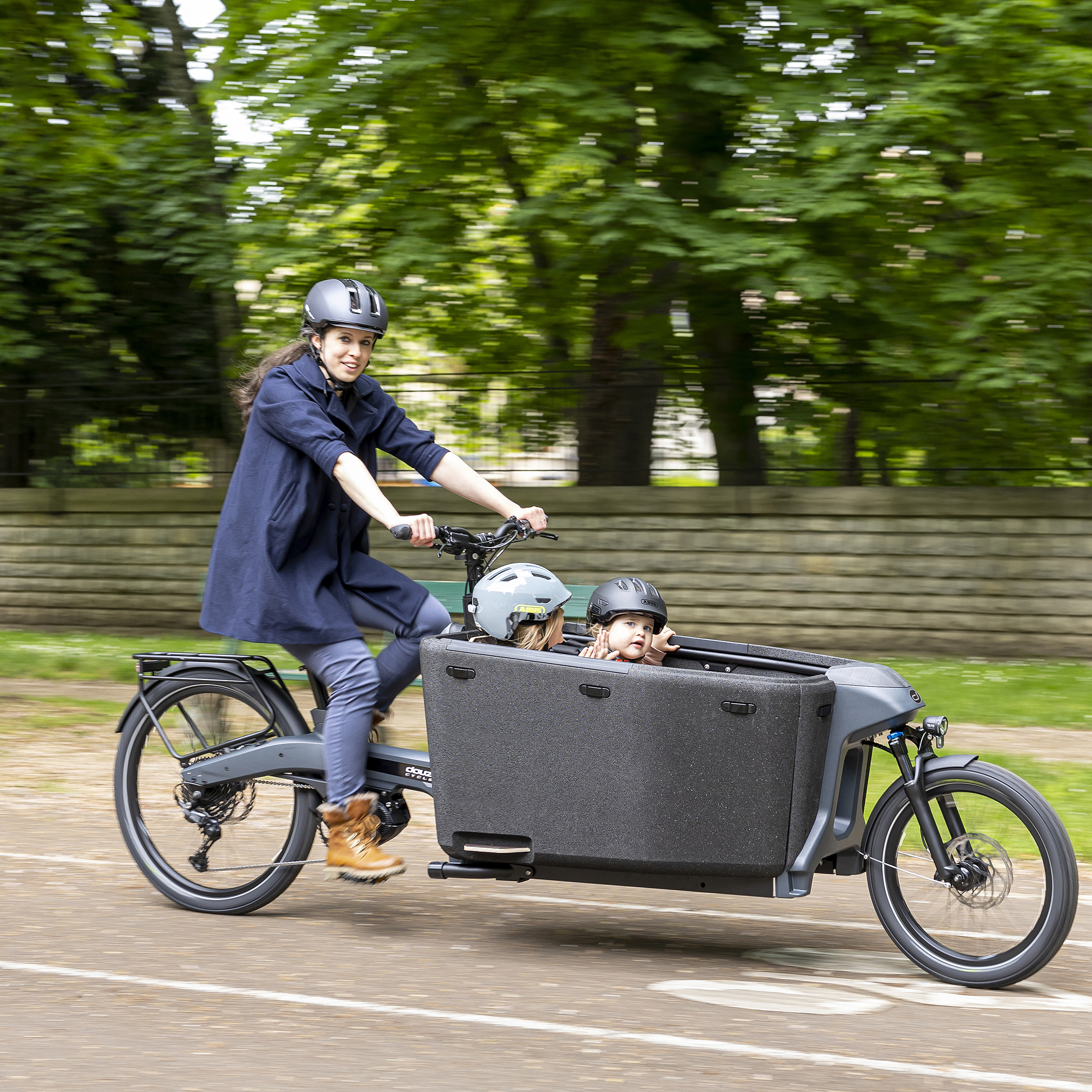 Photo d’un vélo cargo biporteur Heta Douze Cycles transportant 2 enfants en ville.