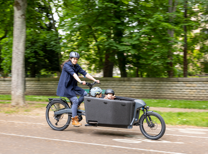 Photo d’un vélo cargo biporteur Hêta Douze Cycles transportant 2 enfants en ville.